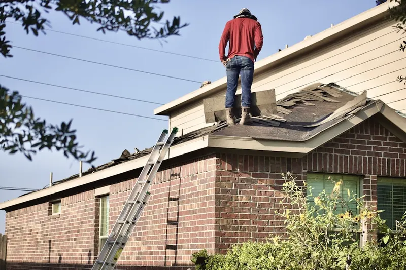 Professional roofer working on a residential roof in Monticello Colleyvlle